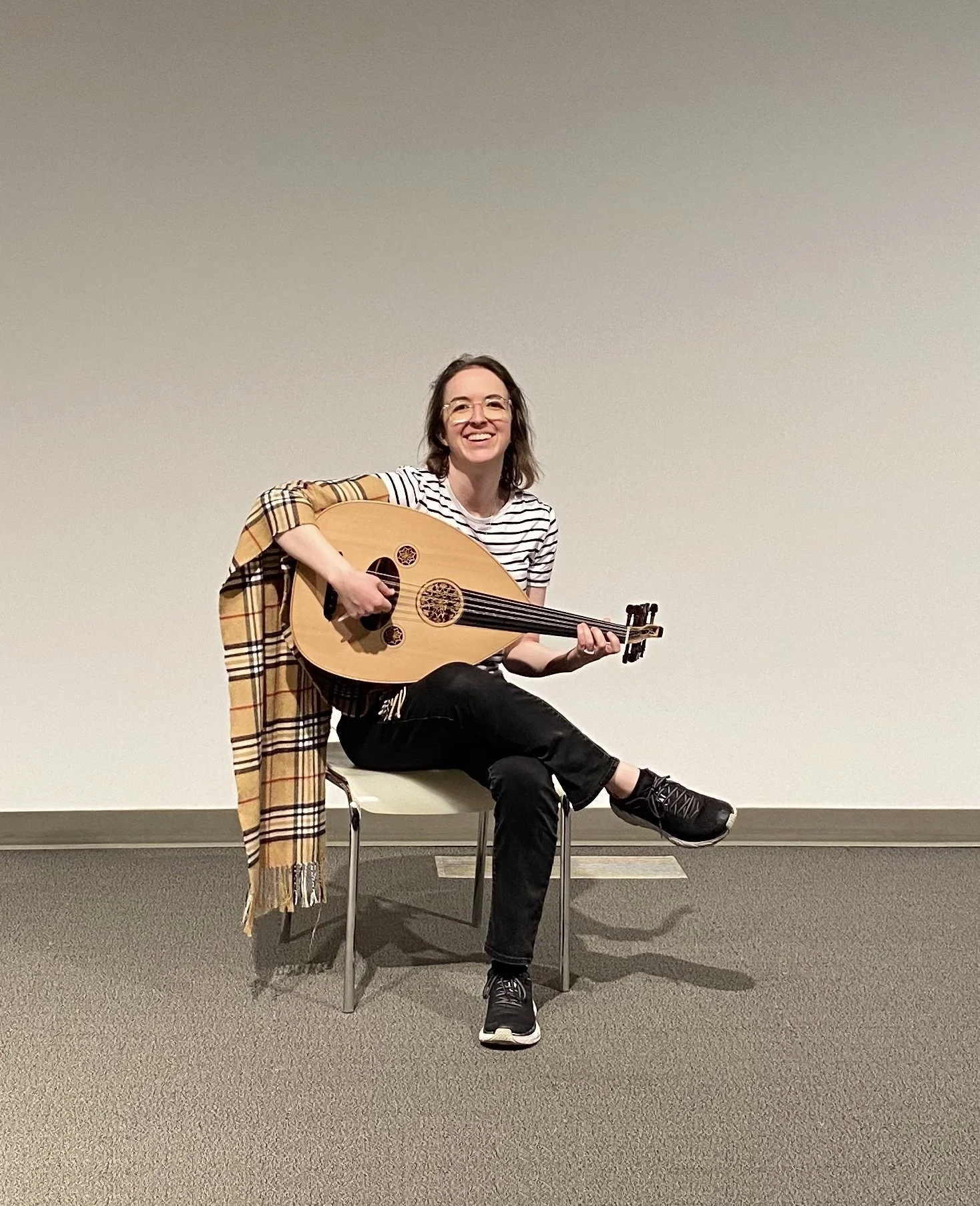 Melissa holding an oud and laughing